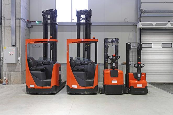 industrial forklifts carrying large crates in factory